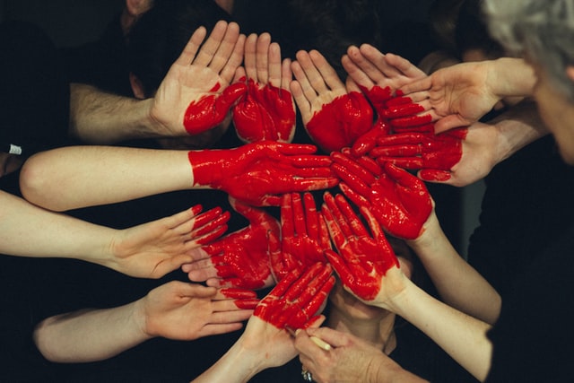 many hands together with red heart - student mental health