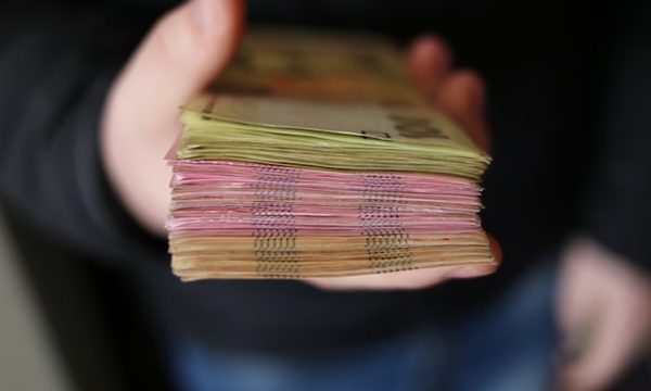 A man holding a stack of cash.