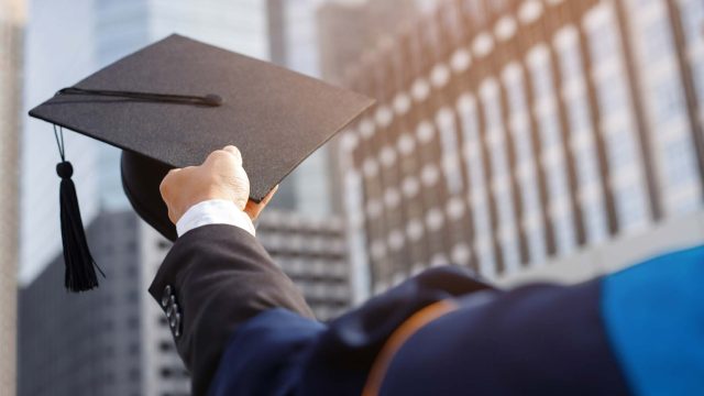 A student holding a graduation cap