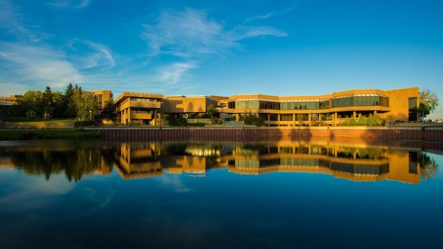 An outside view of Lakehead University's Thunder Bay campus sitting on the edge of Lake Tamblyn in Ontario, Canada.